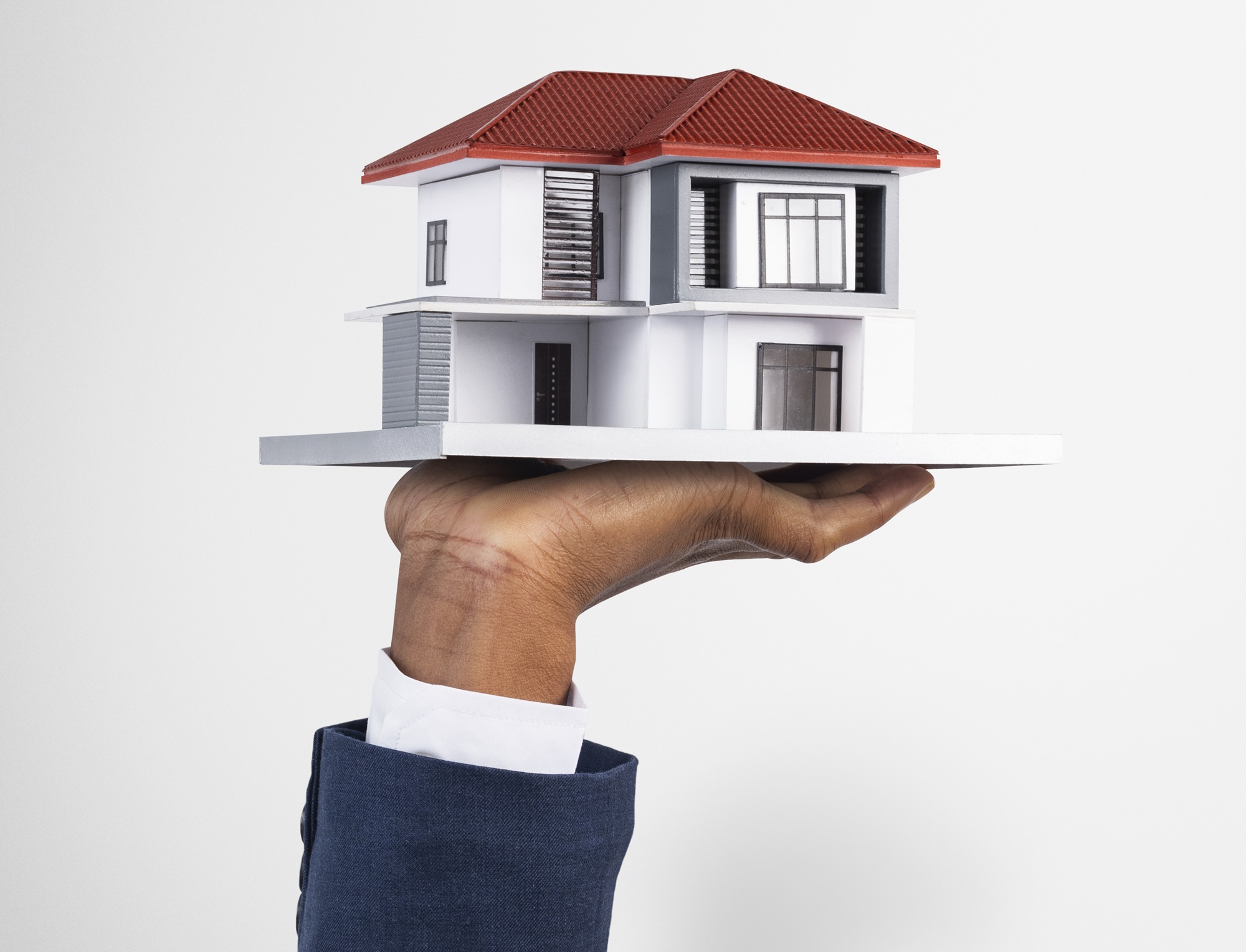 Hand holding house real estate and property model